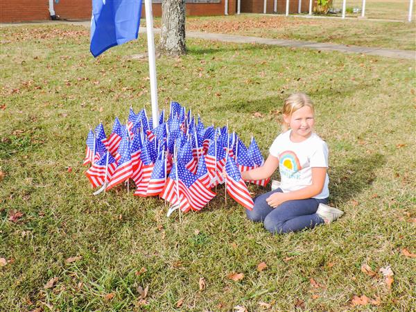 Students holding up homemade signs for a Veterans Day celebration.